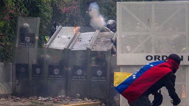 Manifestantes se enfrentan con policías antimotines.