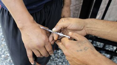 Usuario de hero&iacute;na no identificado siendo inyectado por otro hombre en una calle cerca de una franja conocida como la &ldquo;milla de la metadona&rdquo; en Boston. un usuario de hero&iacute;na no identificado siendo inyectado por otro hombre en una calle cerca de una franja conocida como la &ldquo;milla de la metadona&rdquo; en Boston.&nbsp;