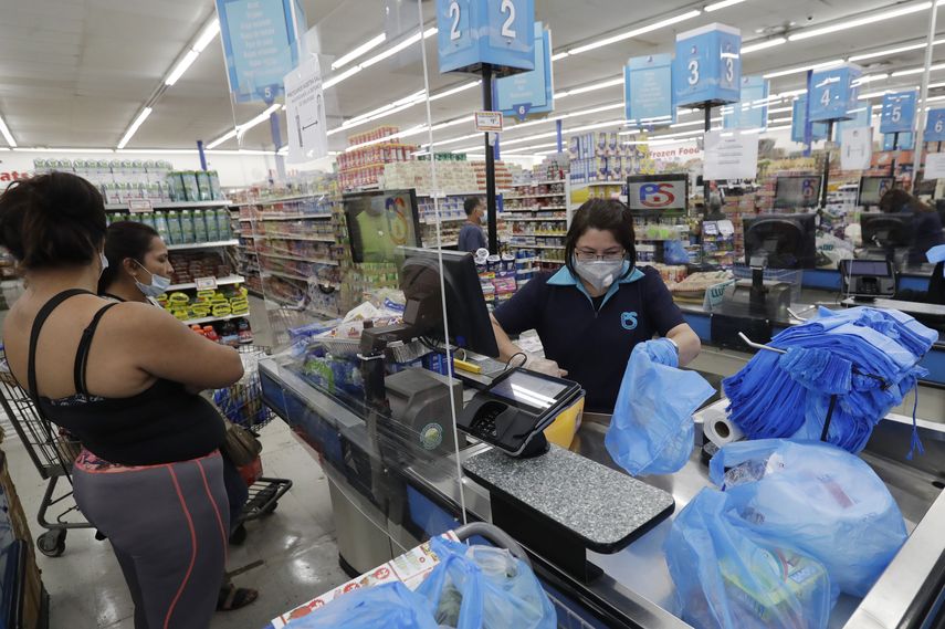 La cajera Rosario Vargas (al centro) coloca productos en bolsas en el supermercado Presidente en La Peque&ntilde;a Habana, en Miami.&nbsp; &nbsp;