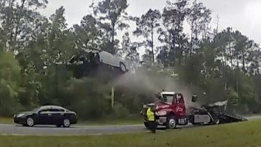 En esta imagen tomada de un video grabado por la cámara corporal de un policía y proporcionada por el Departamento de Policía del condado de Lowndes, un vehículo sale volando tras subir a la rampa de una grúa, en una autopista de Georgia, el miércoles 24 de mayo de 2023, en el condado de Lowndes, Georgia.&nbsp;