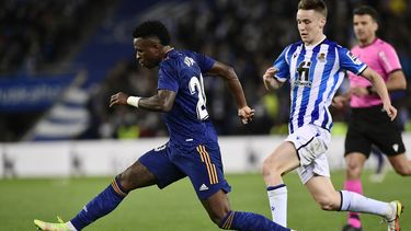 El extremo brasileño Vinícius Júnior, centro, del Real Madrid, avanza con el balón ante la marca del defensor Aihen Muñoz, de la Real Sociedad, en duelo de la Liga en el estadio Reale Arena de San Sebastián, España, el sábado 4 de diciembre de 2021.&nbsp;