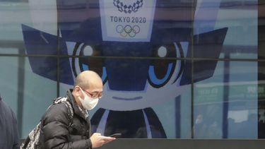 Un hombre camina frente a una pantalla donde se publicitan los Juegos Olímpicos en Tokio, el miércoles 27 de enero de 2021&nbsp;