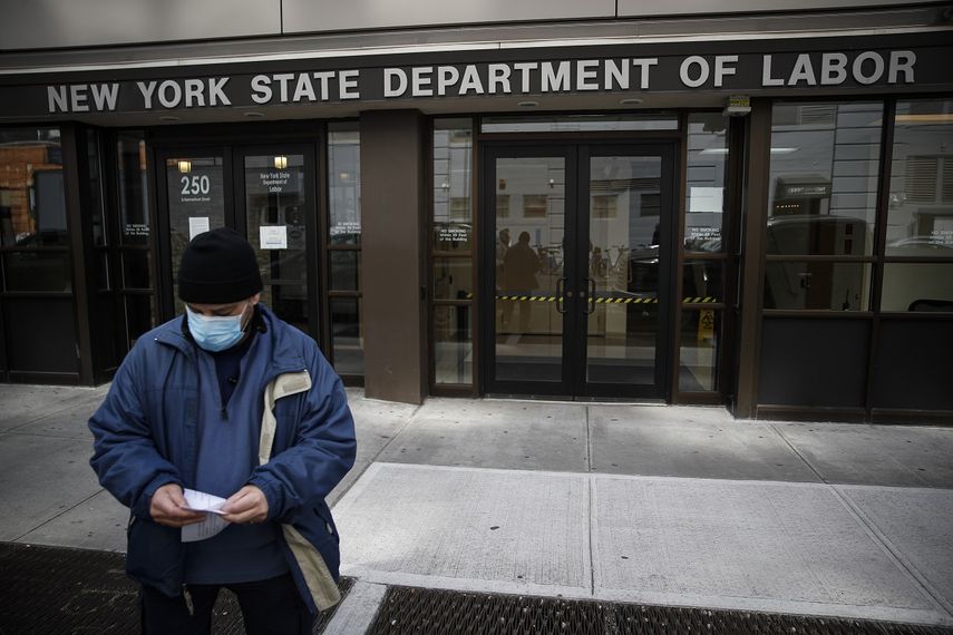 Fotografía del 18 de marzo de 2020 frente al Departamento de Trabajo en Nueva York, un hombre con una máscara para protegerse del coronavirus a las puertas de la oficina de empleo. 