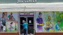 Un hombre mira a través de la puerta de entrada de un centro de asistencia laboral. Un hombre mira a través de la puerta de entrada de un centro de asistencia laboral.