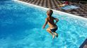 Un niño se lanza a una piscina.