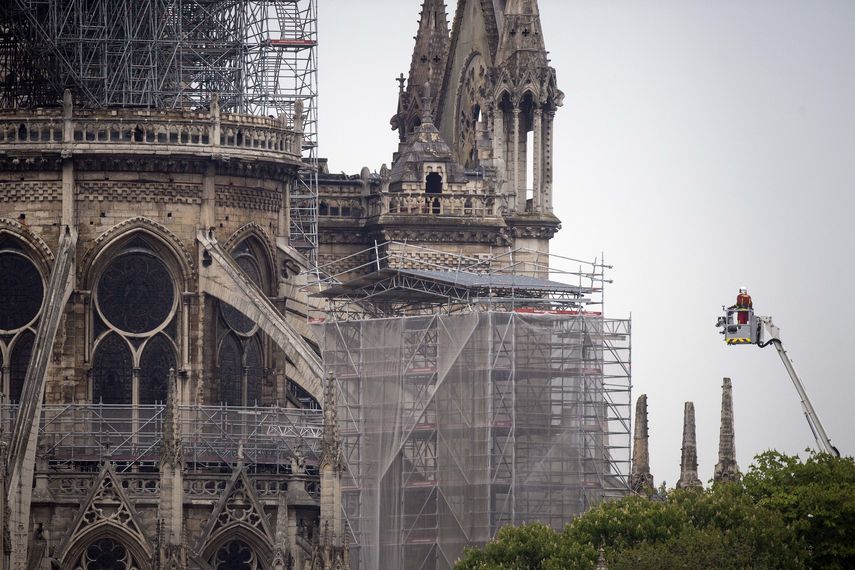 Los bomberos trabajan en la catedral de Notre-Dame después de un incendio masivo que provocó el colapso de su torre y techo mientras se conservaba la estructura principal.