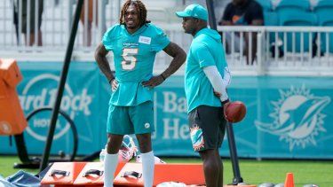 El cornerback de los Dolphins de Miami, Jalen Ramsey, se para junto a un miembro del equipo de coaches durante una práctica, el 27 de julio de 2023.
