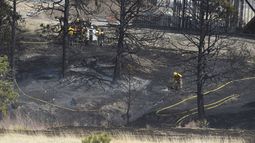 Bomberos trabajando en una zona de árboles quemados frente a un inmueble en construcción, el viernes 22 de abril de 2022, en Colorado Springs, Colorado.&nbsp;