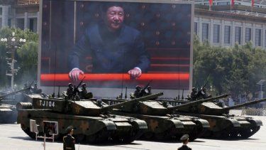 El presidente de China, Xi Jinping, aparece en una pantalla mientras varios tanques de Tipo 99A2 participan en un desfile en Pekín.