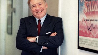 El actor y director Mel Brooks posa junto a un afiche enmarcado de su película de 1974 Blazing Saddles en Los Angeles el 23 de julio de 1991. Brooks publicó su libro de memorias All About Me!: My Remarkable Life in Show Business.