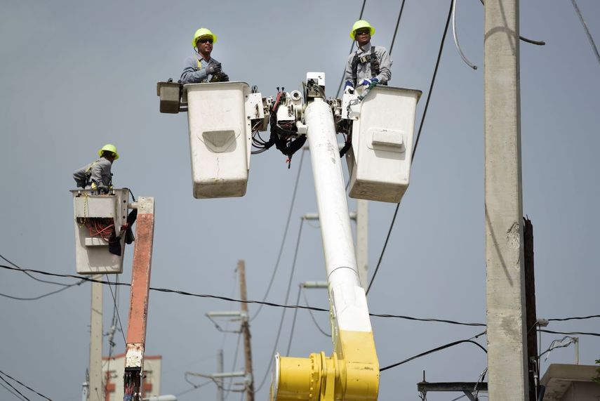 Trabajadores de la Autoridad de Energía Eléctrica de Puerto Rico trabajan en cables dañados por el huracán María en la comunidad Cantera en San Juan.&nbsp;