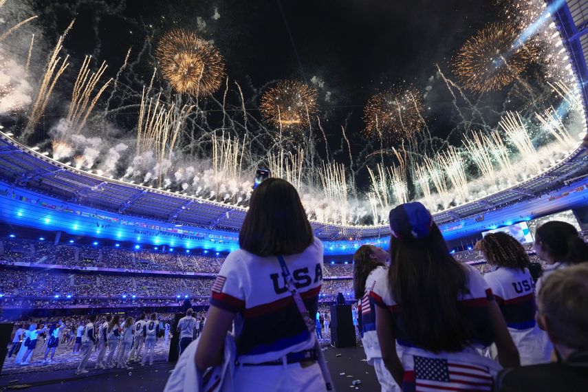 Atletas estadounidenses observan la explosión de fuegos artificiales durante la ceremonia de clausura de los Juegos Olímpicos de Verano de 2024 en el Stade de France, el lunes 12 de agosto, en Saint-Denis, Francia.