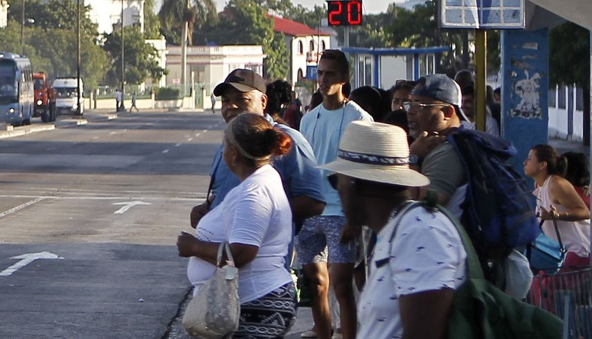 Varias personas esperan un ómnibus en La Habana mientras los diputados del Parlamento unicameral cubano debaten sobre la nueva Constitución.