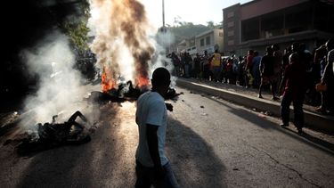 Un grupo de personas observa los cadáveres de presuntos pandilleros que fueron quemados vivos por una turba en la sección Canape Vert de Puerto Príncipe, Haití, el lunes 24 de abril de 2023.