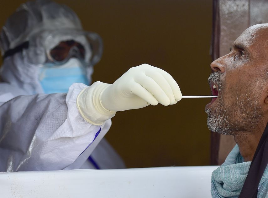 Un funcionario de salud toma una muestra de un hisopo de un hombre para detectar el coronavirus COVID-19 en un punto de prueba en Allahabad el 7 de agosto de 2020. El recuento de casos de coronavirus oficial de la India alcanz&oacute; los dos millones el 7 de agosto, duplic&aacute;ndose en tres semanas a medida que la pandemia se extiende en ciudades m&aacute;s peque&ntilde;as y &aacute;reas rurales, con expertos advirtiendo que el costo real podr&iacute;a ser mucho mayor.