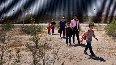 Una familia de cinco personas que dijo ser de Guatemala y un hombre que viaja con ellos que afirma es oriundo de Perú, de camisa rosa, caminan por el desierto tras cruzar el muro fronterizo en el Sector de Tucson de la frontera Estados Unidos-México, el martes 29 de agosto de 2023, en el Monumento Nacional Organ Pipe Cactus cerca de Lukeville, Arizona.&nbsp;
