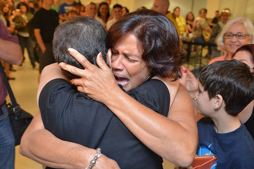 Alina Ortega abraza a su hermana Damay (de espaldas) la noche del lunes en el aeropuerto de Miami. (Foto: Álvaro Mata)