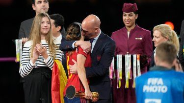 El presidente de la federación española de fútbol, Luis Rubiales (derecha), abraza a la volante Aitana Bonmatí en el podio tras la victoria de España ante Inglaterra en la final del Mundial femenino, el domingo 20 de agosto de 2023, en Sídney.