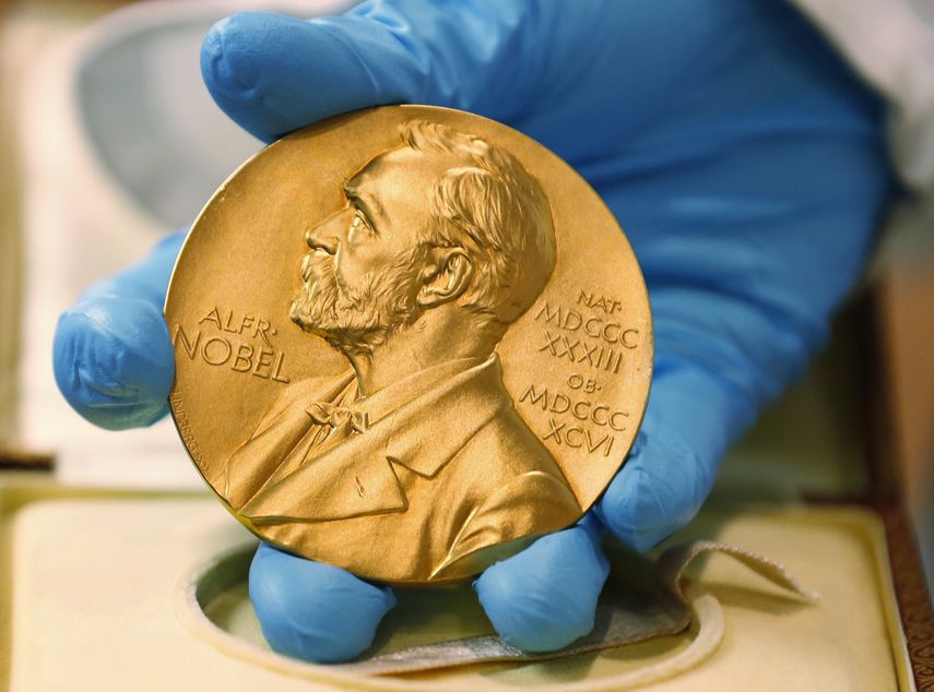 En esta imagen de archivo, tomada el 17 de abril de 2015, un empleado de la biblioteca nacional muestra una medalla de oro del Premio Nobel.&nbsp;