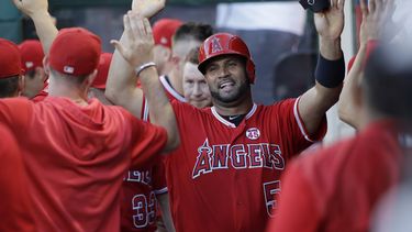 El jugador de los Angelinos de Los Ángeles Albert Pujols (centro) recibe la felicitación de sus compañeros&nbsp; tras anotar, en el quinto inning del juego ante los Piratas de Pittsburg.