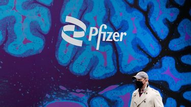 Un hombre camina junto al edificio del gigante farmacéutico Pfizer, en Nueva York.