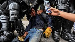 Agentes de la policía colombiana arrestan a un manifestante durante una protesta contra el gobierno en Cali, Colombia.
