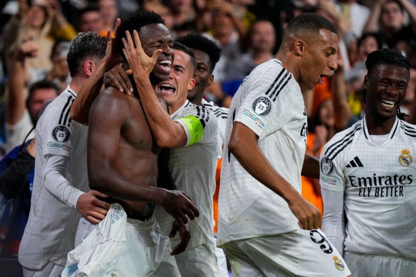 Vinícius Junior celebra con sus compañeros tras anotar el cuarto gol del Real Madrid en la victoria 5-2 ante Borussia Dortmund en la Liga de Campeones, el martes 22 de octubre de 2024, en Madrid.