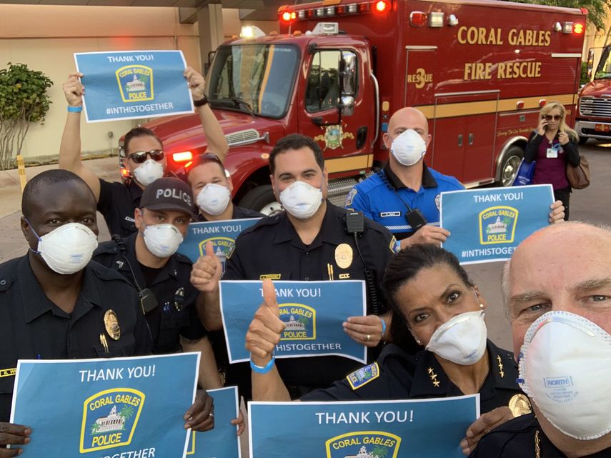 Miembros del cuerpo polic&iacute;aco de&nbsp;City Beautiful saludan a personal del Coral Gables Hospital.