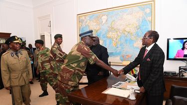 El presidente de Zimbabue, Robert&nbsp;Mugabe&nbsp;(d), saluda al comandante de las Fuerzas Aéreas del país, Perence Shiri (c), tras una reunión con jefes militares y de seguridad en Harare. Durante un mensaje televisado, Mugabe insistió en la necesidad de llevar a cabo acciones para devolver al país a la normalidad.&nbsp;