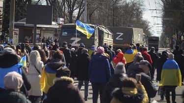 Personas con banderas ucranianas caminan hacia los camiones militares rusos durante una marcha contra la ocupación de Rusia, en Jersón, Ucrania, el domingo 20 de marzo de 2022.&nbsp;