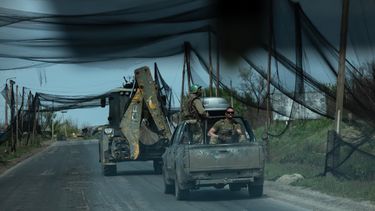 En esta fotografía distribuida el 7 de mayo de 2026 y publicada el 8 de mayo de 2026 por el servicio de prensa de la 93.ª Brigada Mecanizada Separada de Kholodnyi Yar de las Fuerzas Terrestres de Ucrania, militares ucranianos del batallón Cuervo Negro viajan en vehículos por una carretera cubierta con una red para proteger los vehículos de los ataques de drones en un lugar no revelado, en medio de la invasión rusa de Ucrania.&nbsp; 