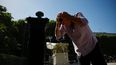 Un hombre se refresca echándose agua de una fuente en el cabello en el Jardín del Palais Royal, en el centro de París, el 26 de mayo de 2026, mientras una ola de calor azota Francia.