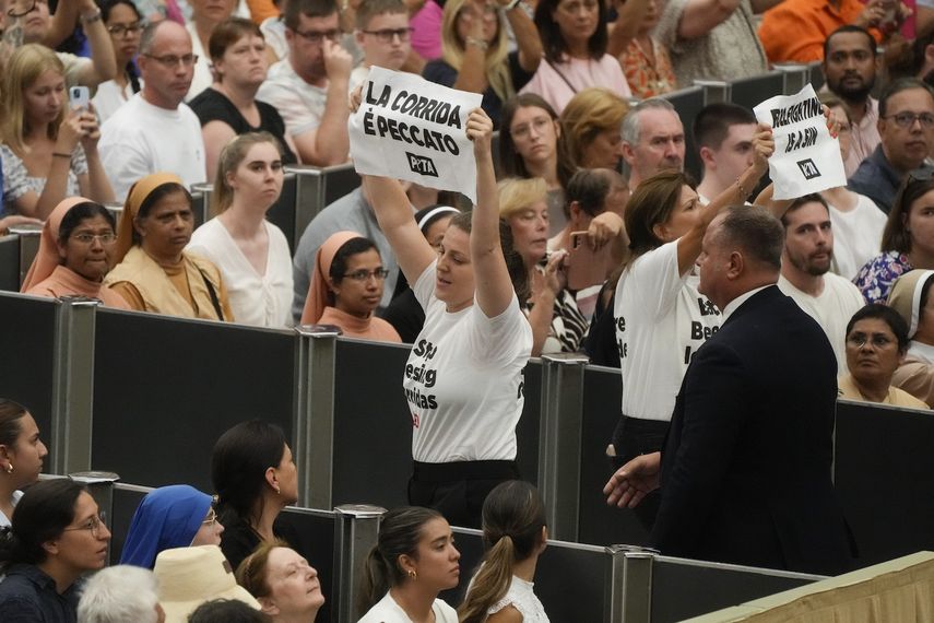 Dos manifestantes con camisetas que dicen dejen de bendecir las corridas sostienen carteles con el mensaje las corridas son pecado durante la audiencia general del papa Francisco en el salón Pablo VI del Vaticano, el miércoles 7 de agosto de 2024.&nbsp;