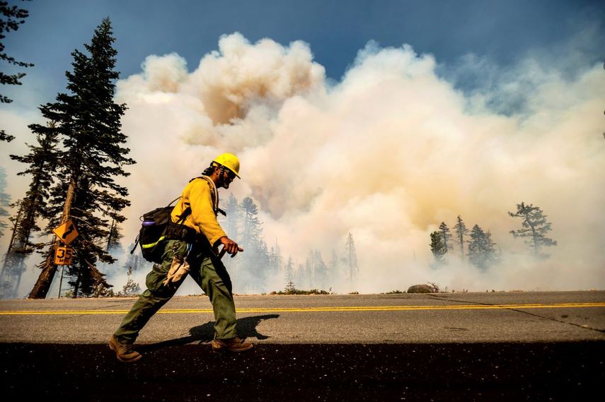 Un bombero camina por la autopista 89 frente al incendio forestal Dixie en el Bosque Navional Lassen, California