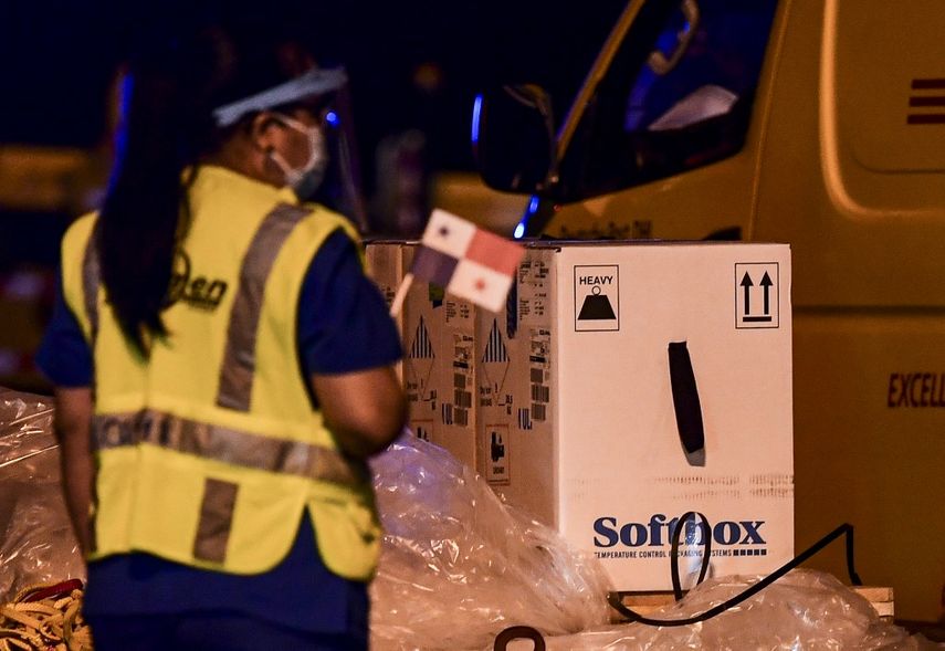 Workers unload containers carrying the first shipment of the Pfizer/BioNTech COVID-19 vaccine for Panama, from a courier aircraft transporting some 12,840 doses of the vaccine into the country, at Tocumen International Airport in Panama City on January 20, 2021.