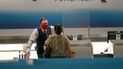 El agente de boletos de American Airlines, Henry Gemdron, a la izquierda, habla con una cliente en el Aeropuerto Internacional de Miami, el 30 de septiembre de 2020.