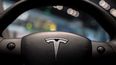 Logo del fabricante Tesla en el timón de un auto.