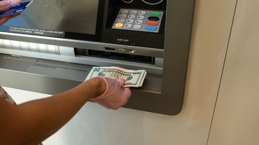 Un cliente deposita dinero en un cajero automático de un banco.