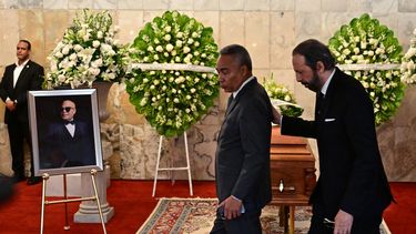 El cantante y compositor dominicano Juan Luis Guerra (derecha) y el periodista dominicano Severo Rivera asisten al velatorio del merenguero Rubby Pérez, quien falleció tras el derrumbe del techo de la discoteca Jet Set donde se presentaba, en el Teatro Nacional de Santo Domingo el 10 de abril de 2025.