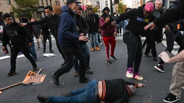 Un partidario del presidente de los Estados Unidos, Donald Trump, tirado en el suelo, recibe un puntapié cuando es atacado por manifestantes anti-Trump en Black Lives Matter Plaza en Washington, DC el 14 de noviembre de 2020.