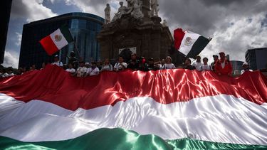 Magistrados y jueces sostienen la bandera de México en una protesta contra la reforma judicial