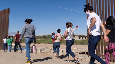 Un grupo de migrantes brasileños ingresan a Estados Unidos desde México el 8 de junio de 2021 a través de una brecha en el muro fronterizo, en Yuma, Arizona, con el fin de solicitar asilo a las autoridades migratorias estadounidenses