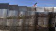 Una bandera estadounidense ondea detrás de un muro fronterizo que divide México y Estados Unidos, en Tijuana, México, el 21 de noviembre de 2018.&nbsp;