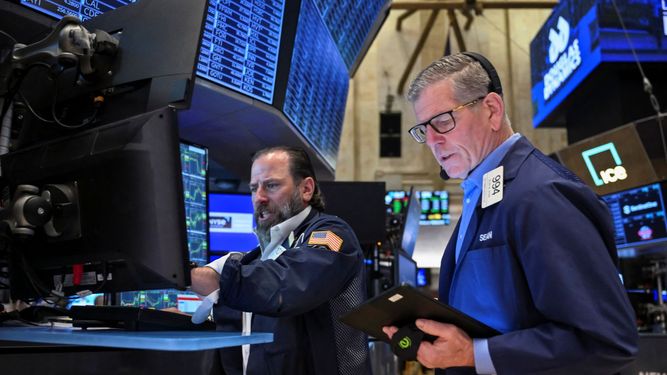 Agentes de la Bolsa de Nueva York trabajan en el piso de remate.