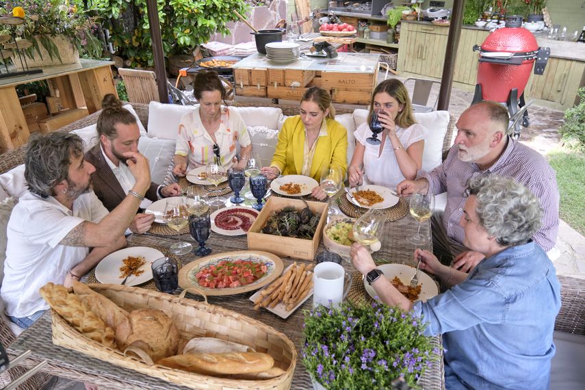 En esta imagen proporcionada por Discovery, de izquierda a derecha: Diego Guerrero, Carlos Sánchez, Mila, Inés Andrés, Carlota Andrés, José Andrés y Pepa Muñoz disfrutan de una comida preparada por los chefs en la casa de Muñoz en una escena de la serie de Discovery + Jose Andres and Family in Spain.