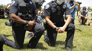 Un par de polic&iacute;as se arrodilla durante un evento de solidaridad el mi&eacute;rcoles 3 de junio de 2020, en Fairfield, California.&nbsp;