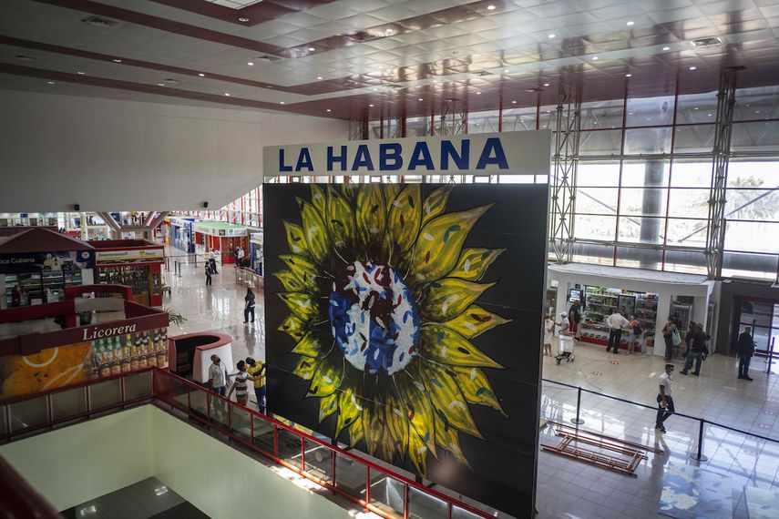Trabajadores revisan el montaje de la obra artística titulada Cachita del artista cubano Michel Mirabal en el aeropuerto de La Habana, Cuba, el lunes 18 de octubre de 2021.&nbsp;
