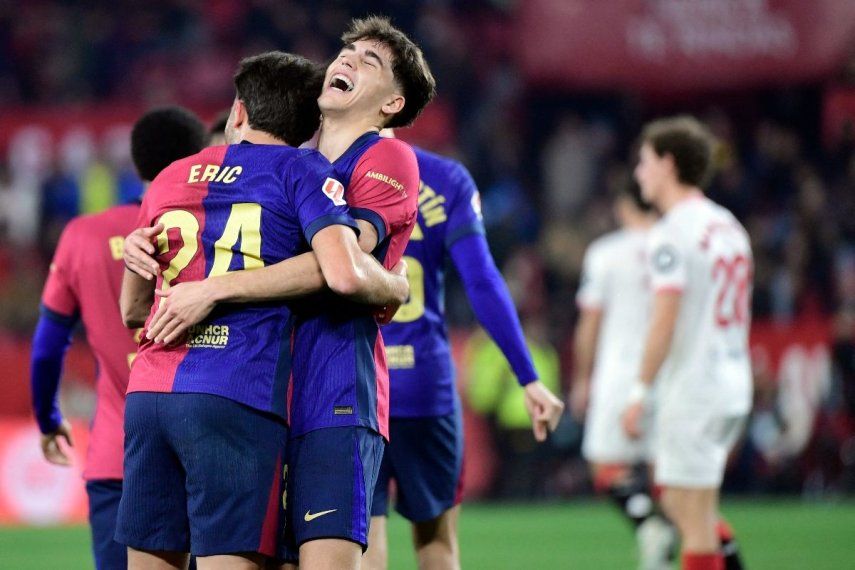 El defensa español #24 del Barcelona, Eric García, celebra con el defensa español #02 del Barcelona, Pau Cubarsi, después de anotar el cuarto gol de su equipo durante el partido de fútbol de la liga española entre el Sevilla FC y el FC Barcelona en el Estadio Ramón Sánchez Pizjuan en Sevilla el 9 de febrero de 2025.&nbsp;