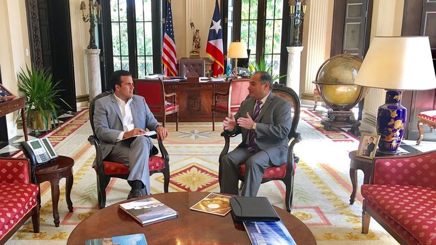 El presidente del Partido Demócrata de Puerto Rico, Charlie Rodríguez (der.), conversa con el gobernador de la isla, Ricardo Rosselló.