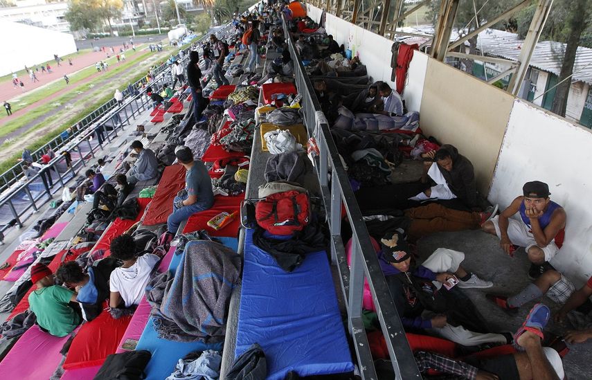 Grupos de migrantes toman un descanso en el complejo deportivo Jesús Martínez Palillo de Ciudad de México.